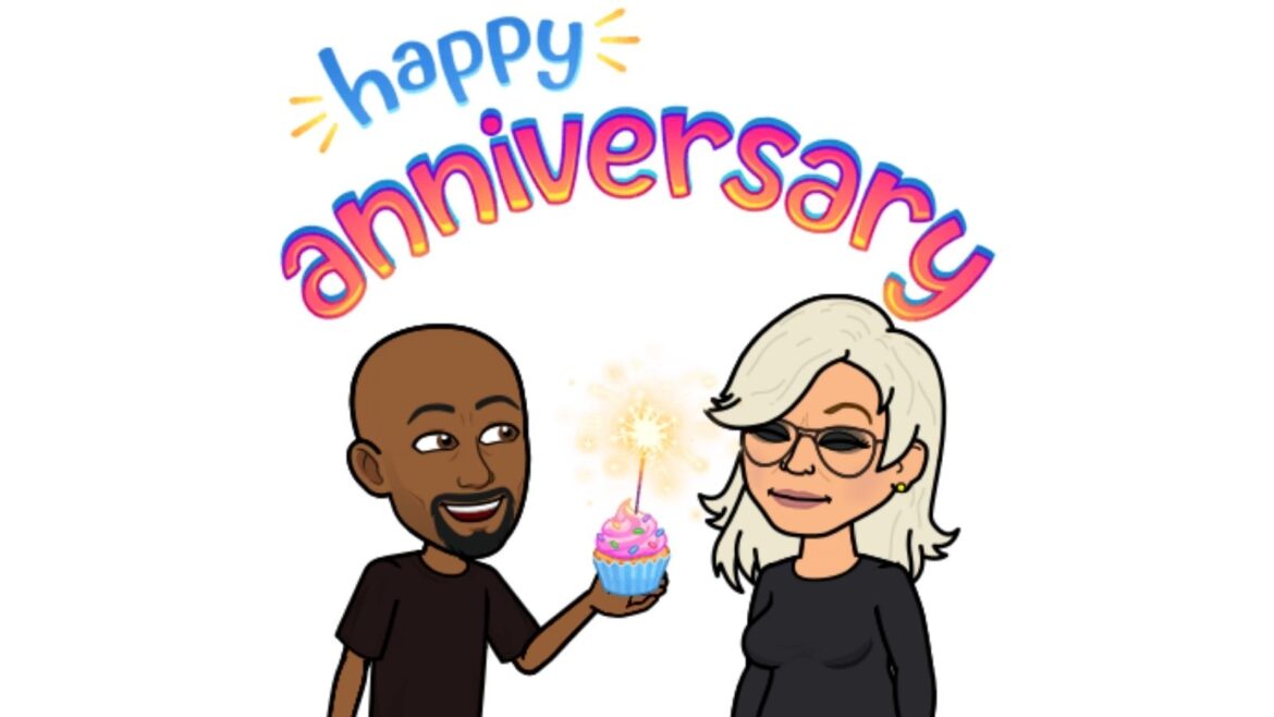 A man and woman holding a candle in front of the word " happy anniversary ".