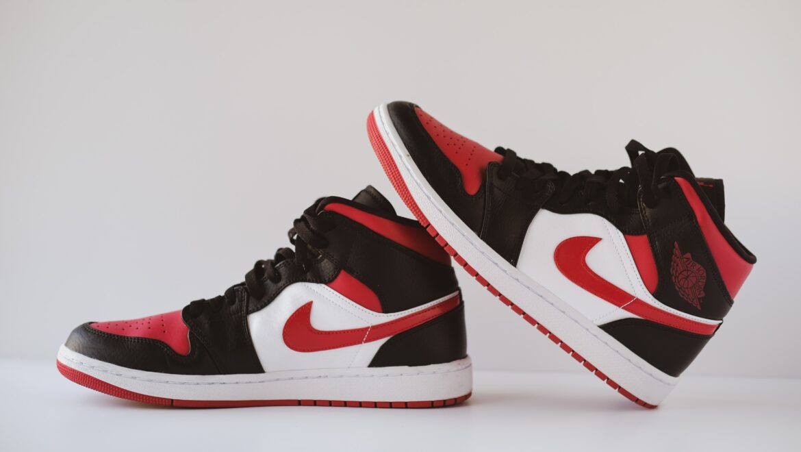 A pair of red and black sneakers on top of the floor.