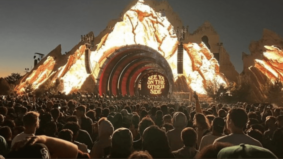 A crowd of people watching an outdoor concert.