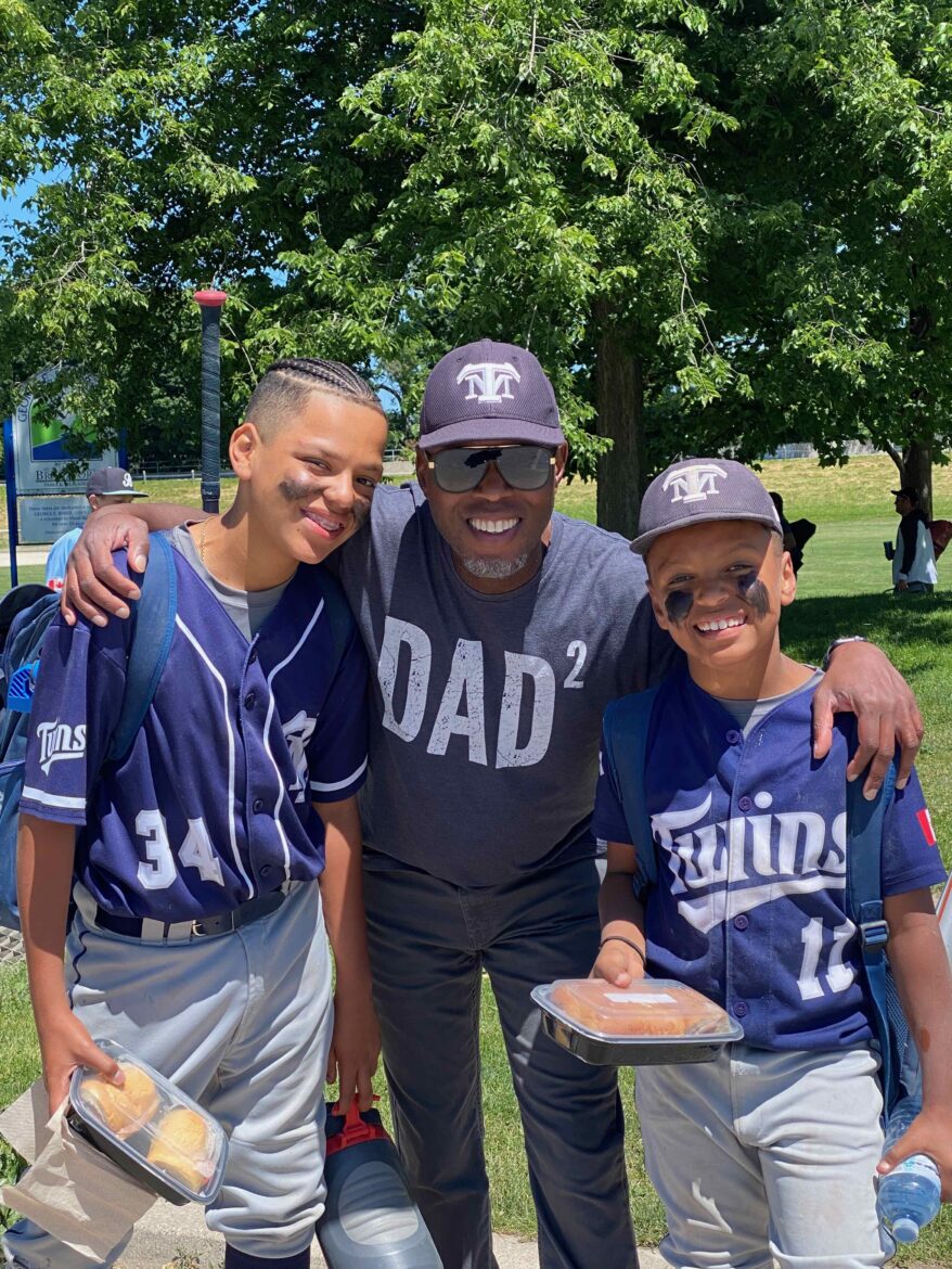 Three young men posing for a picture in baseball uniforms.