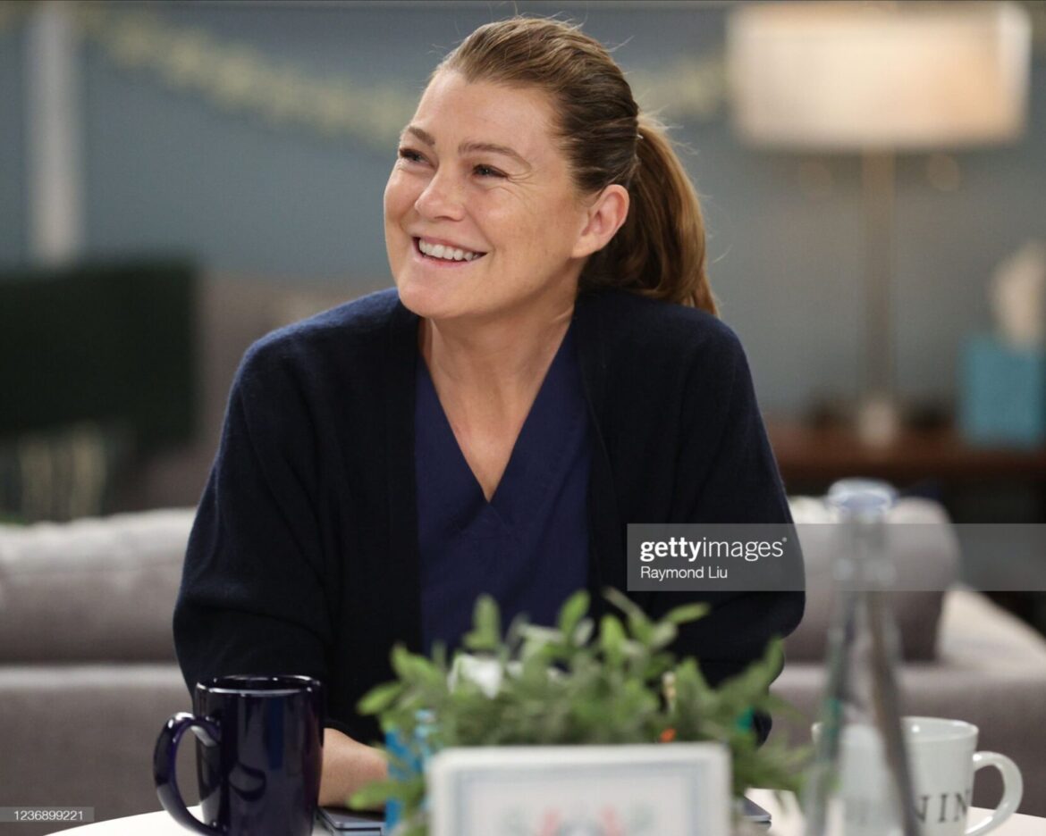 A woman sitting at a table with a cup of coffee.