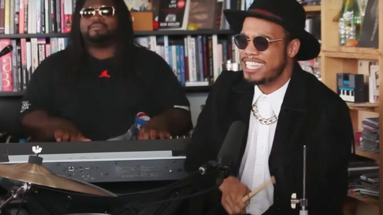 A man in black jacket sitting next to another man.